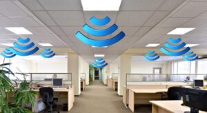 Wireless signal icons overlaid over a modern open office, representing office Wi-Fi coverage